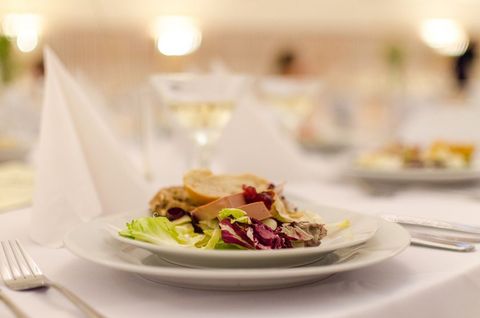 Elegant plated appetizer with mixed salad and foie gras on white linen for formal banquet