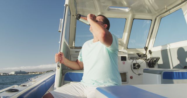 Caucasian man sitting drinking on deck of small boat sailing on a sunny day. Leisure, hobbies, free time, travel and vacations.