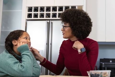 African american mother and daughter sharing tender moment at kitchen counter, bonding