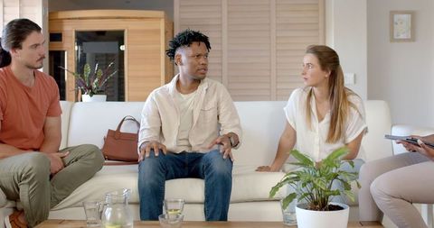 Diverse group collaborating in modern living room with tablet