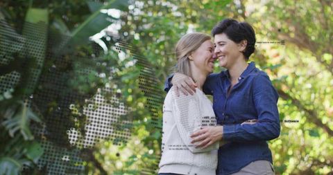 Two women embracing and smiling in sunlit garden with halftone code overlay