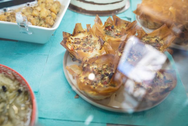 Close-up of baked food on plate in display cabinet at cafe. unaltered, temptation, food, cafeteria and small business concept.