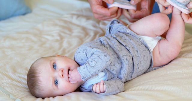 Parent Changing Baby Diaper while Baby Sucking Thumb on Bed - Download Free Stock Images Pikwizard.com