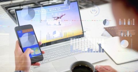 Planning trip on laptop and phone with travel booking dashboard, analytics and coffee