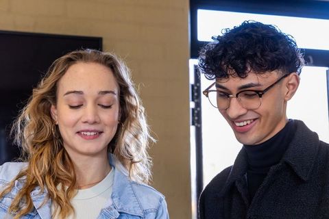 Young coworkers collaborating and smiling in modern office lobby with natural light