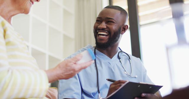 Smiling Male Nurse Assisting Elderly Patient During Consultation - Download Free Stock Images Pikwizard.com