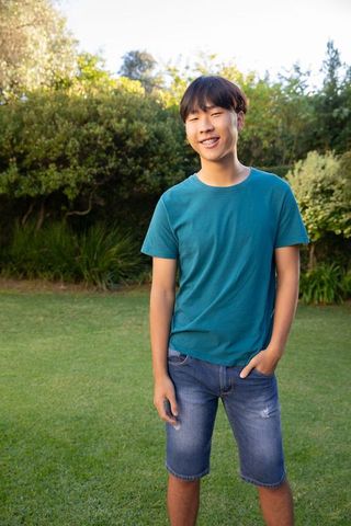 Casual young asian man relaxing in green garden outdoors