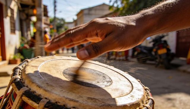 Sunlit street drummer hitting worn hand drum with motion blur and dust sparks