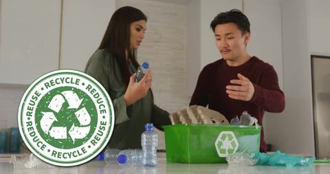 Diverse Couple Enthusiastically Recycling in Modern Kitchen