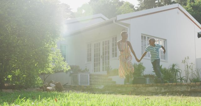 Mother and Child Holding Hands in Front of Modern Home on Sunny Day - Download Free Stock Images Pikwizard.com