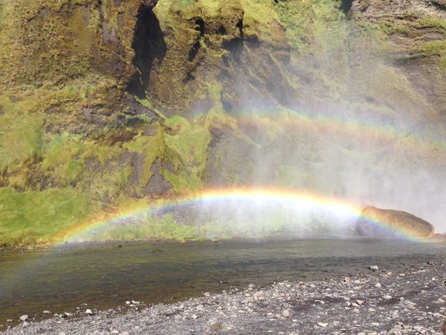 Scenic Rainbow Over Rocky Stream Near Lush Green Cliff - Download Free Stock Photos Pikwizard.com