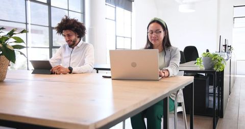 Colleagues Working at Shared Desk in Modern Office