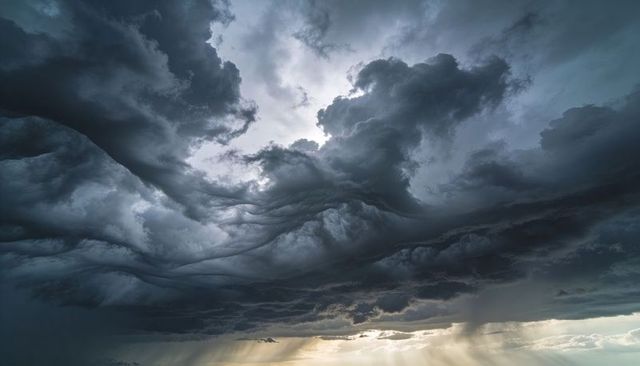 Roaring Storm Clouds Churning Over Low Horizon with Sunbeams, Rain Shafts, Mammatus Pockets