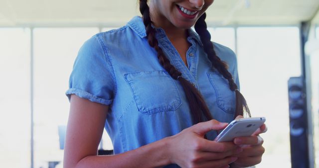 Smiling Woman Typing on Smartphone in Casual Office - Download Free Stock Images Pikwizard.com