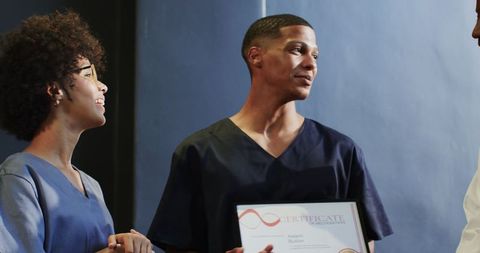 Young professional holding certificate celebrating achievements