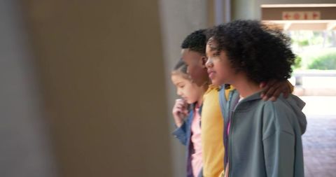 Diverse teenage friends walking in school corridor wearing backpacks, showing friendship and unity