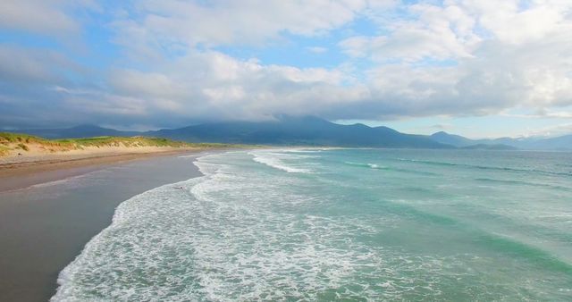 A serene beach with gentle waves lapping the shore under a vast sky, with copy space - Download Free Stock Photos Pikwizard.com