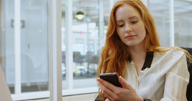 Focused Caucasian Young Woman Checking Her Phone at Office Desk - Download Free Stock Images Pikwizard.com