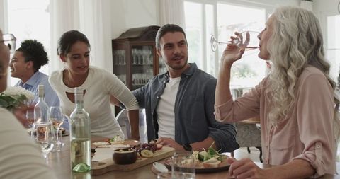 Friends Smiling at Elegant Dinner Gathering with Wine
