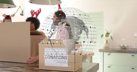 Packing holiday donation boxes on kitchen island with augmented reality globe overlay