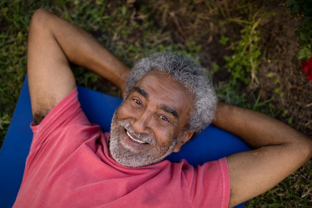Smiling Senior Man Relaxing on Exercise Mat in Park - Download Free Stock Photos Pikwizard.com