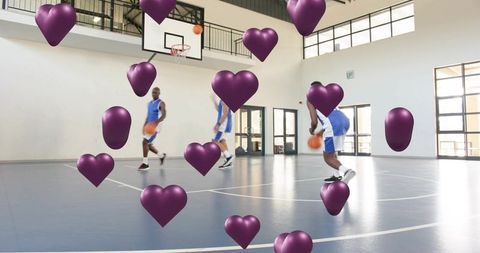 Dribbling basketball players on indoor court with purple heart overlays