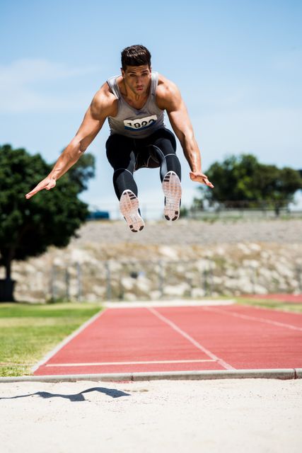 Athlete performing a long jump during a competition