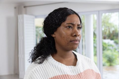African American Woman Contemplating Home Life by Window