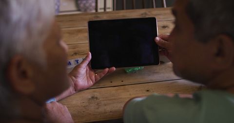Senior Couple Using Tablet at Home Discussing Technology Together