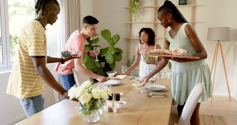 Friends Preparing Dining Table Gathering Laughter Indoors Afternoon