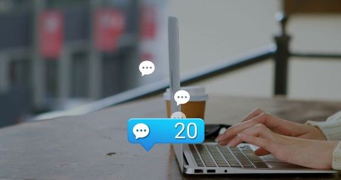 Typing on laptop with coffee cup and 20 chat notifications for remote work productivity