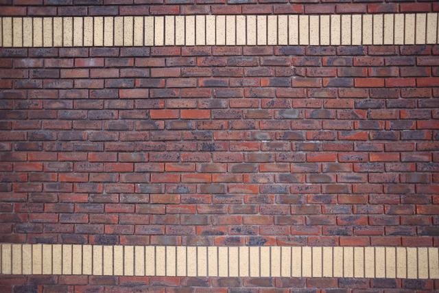 This image shows a modern brick wall with horizontal beige stripes, creating a unique and stylish pattern. The red bricks and beige stripes provide a striking contrast, making it suitable for use in architectural designs, construction projects, and as a background for various creative works. Ideal for presentations, websites, and marketing materials related to building materials, home improvement, and urban design.
