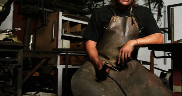 Craftsman in Workshop Holding Tool, Wearing Leather Apron - Download Free Stock Images Pikwizard.com