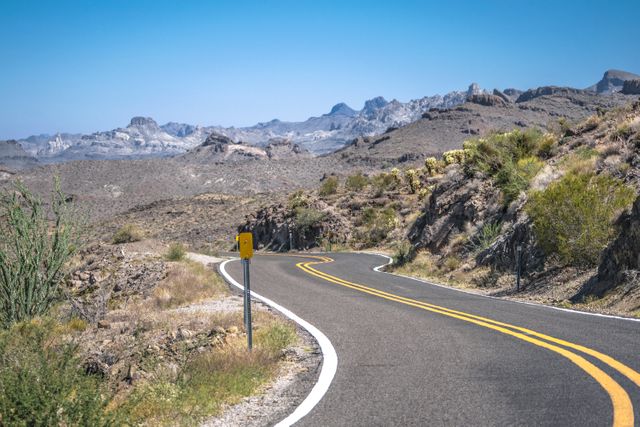 Winding Desert Highway with Mountainous Background - Download Free Stock Photos Pikwizard.com