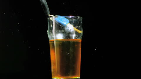 Keys Splashing into Pint Glass with Liquid in Slow Motion