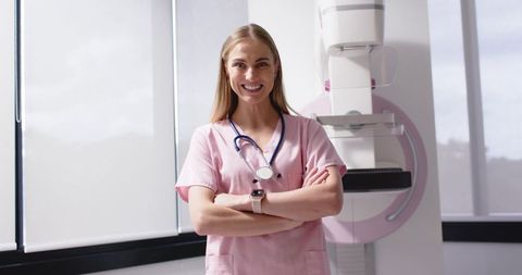 Mammography technologist standing confidently in pink scrubs with stethoscope and smartwatch