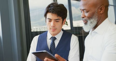 Diverse Professionals Collaborating with Tablet in Modern Office