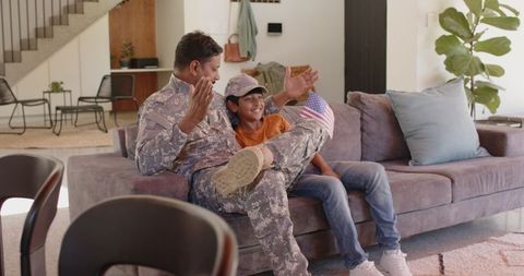 Father in Military Uniform Celebrating with Son at Home