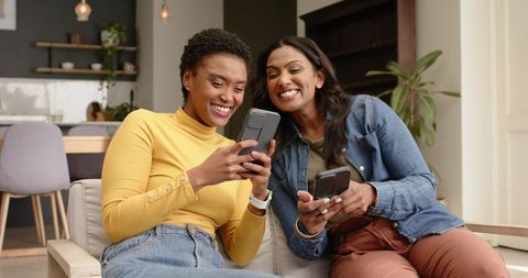 Diverse Friends Enjoying Smartphones Leisurely at Home