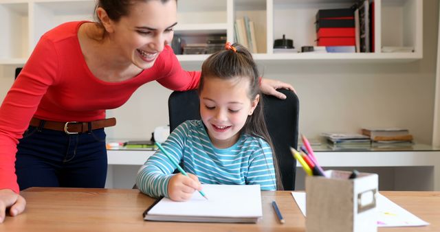 Smiling Young Girl Doing Homework with Mother's Assistance at Home - Download Free Stock Images Pikwizard.com