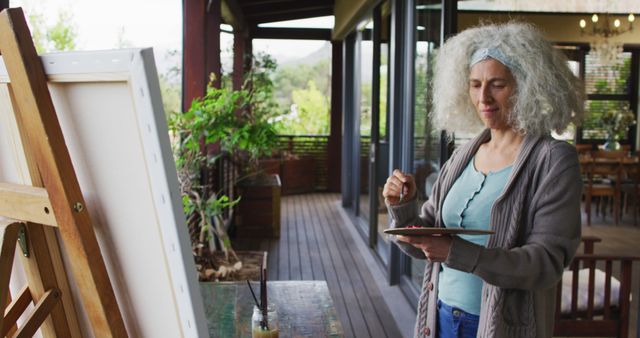 Senior biracial woman painting on balcony - Download Free Stock Photos Pikwizard.com