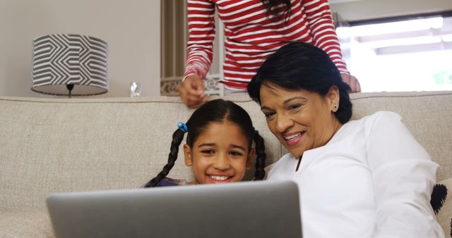 Grandmother and granddaughter using laptop on couch - Download Free Stock Images Pikwizard.com