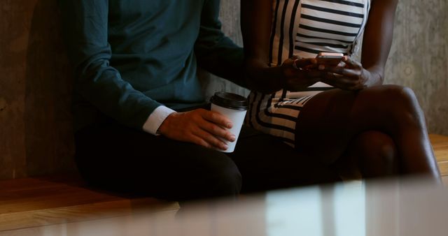 Two People Sitting Together Reading Smartphone in Casual Setting - Download Free Stock Images Pikwizard.com