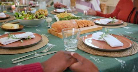 Diverse Family Holding Hands at Cozy Dinner Table Gathering
