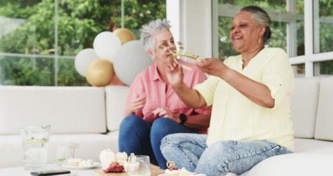 Joyful Senior Multiracial Lesbian Couple Enjoying Birthday Celebration
