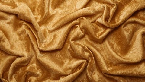 Golden crushed velvet fabric with plush folds and shimmering luster for luxury textiles