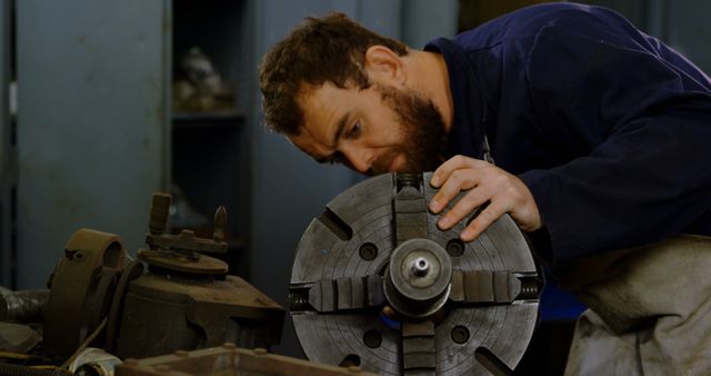 Focused machinist inspecting metal part on lathe in workshop - Download Free Stock Images Pikwizard.com