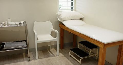 Clinical examination room with medical supplies and exam table