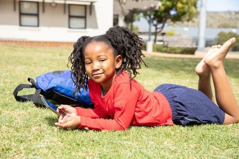 Girl Relaxing on School Lawn Using Smartphone