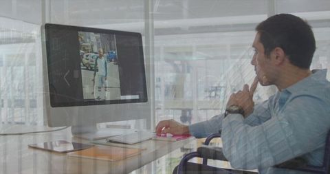 Wheelchair User Engaged with Office Technology at Workspace